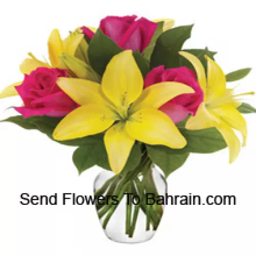 Roses roses et lis jaunes avec des garnitures saisonnières arrangés magnifiquement dans un vase en verre